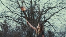  a woman holding up a burning torch 