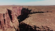 drone flying by canyon in desert