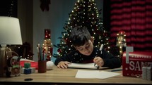 Kid writing Italian Buon Natale on his notebook 