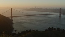 Pan across San Francisco Bay and Golden Gate Bridge during sunrise  