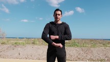 Man In Black Suit Stands With His Arms Folded Outdoor