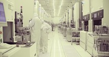 Semiconductor manufacturing facility with workers in clean suits