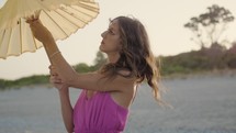 Fashion Girl Pose On The Beach with yellow Chinese umbrella