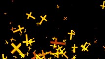 Particles of yellow religious crucifixes pass on the black background