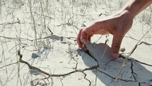 Hand touch drought cracked soil