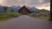 Old Wooden Chapel in the Mountains at Sunset