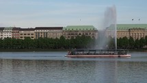 HAMBURG, GERMANY—Boat passing by the Alster Fountain at Binnenalster (meaning Inner Alster lake). 