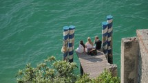 people sit by a lake in italy