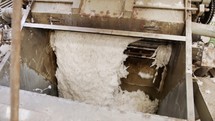 Clean cotton flowing inside a machine in a large industrial cotton gin