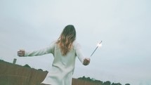 a woman dancing with a sparkler 