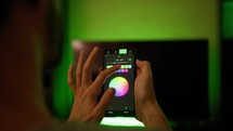Hand of boy change color light of the house with smart phone, home automation concept