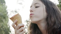 Young girl eating Ice Cream from a cone, enjoying and laughing
