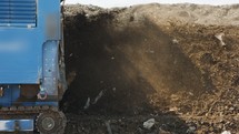 Industrial compost production site. Slow motion footage of large compost turning machine mixing compost piles