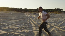 Miltary marine american man training run on the beach at sunset