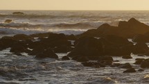 Waves crashing on Northern California coastline during sunset, panning