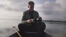 a man reading a Bible in a canoe 