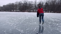 Young Man Ice Skating On Frozen Lake Winter