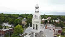 Drone circling a small town's clock tower.
