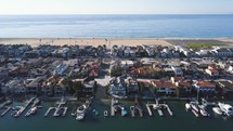 Aerial view of large beautiful boat harbor, houses, peninsula, and beach.
