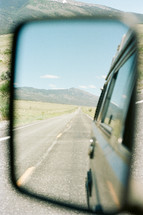 view of the road behind in a rearview mirror 