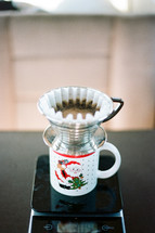 straining coffee into a santa mug 