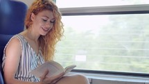 a woman reading riding on a bus 