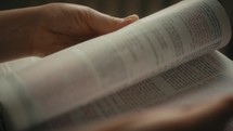 Hands studying old leather bible in private bible study session