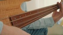 Close up of man practicing guitar skills at home.