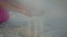 Girl touching sand on the beach