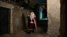 Santa walking around the street of an ancient city on Christmas night 