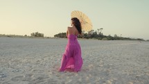 Pink Dressed Girl Stand Alone On Beach At Summer Time with yellow umbrella