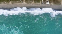 Vertical ocean waves crashing on the shore aerial view