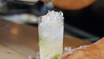 Ice poured in a glass of mojito in slow motion.