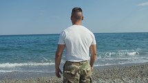 soldier looks at the ocean 