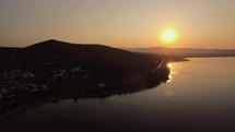 Aerial sunset scene of sea and town on shoreline, Greece