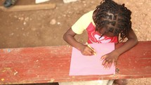 a child coloring in Haiti 