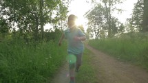 Happy child running in the woods at sunset