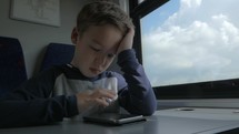 Kid playing on cell when traveling by train