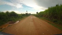 driving down a rural dirt road in Kenya