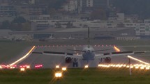 View from behind of a commercial airplane landing on a runway.