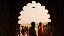 view of men and women standing in desert through temple window 