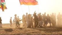 men with flags and drums in the desert