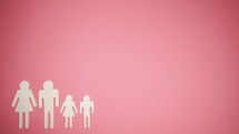 a family of paper dolls on a pink background 