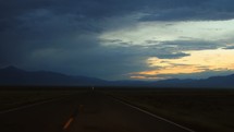 driving down a rural road at sunset 