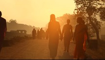 walking down a dirt road in India at sunset 