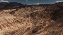 Gravel road between sandstone mountains in Death Valley, aerial view