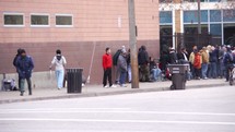 a line of people in front of a homeless shelter 