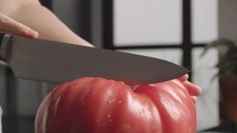 Cutting big juicy tomato