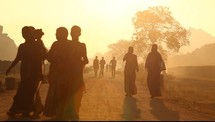 walking down a dirt road in India at sunset 