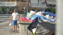 Man throwing trash pack to container